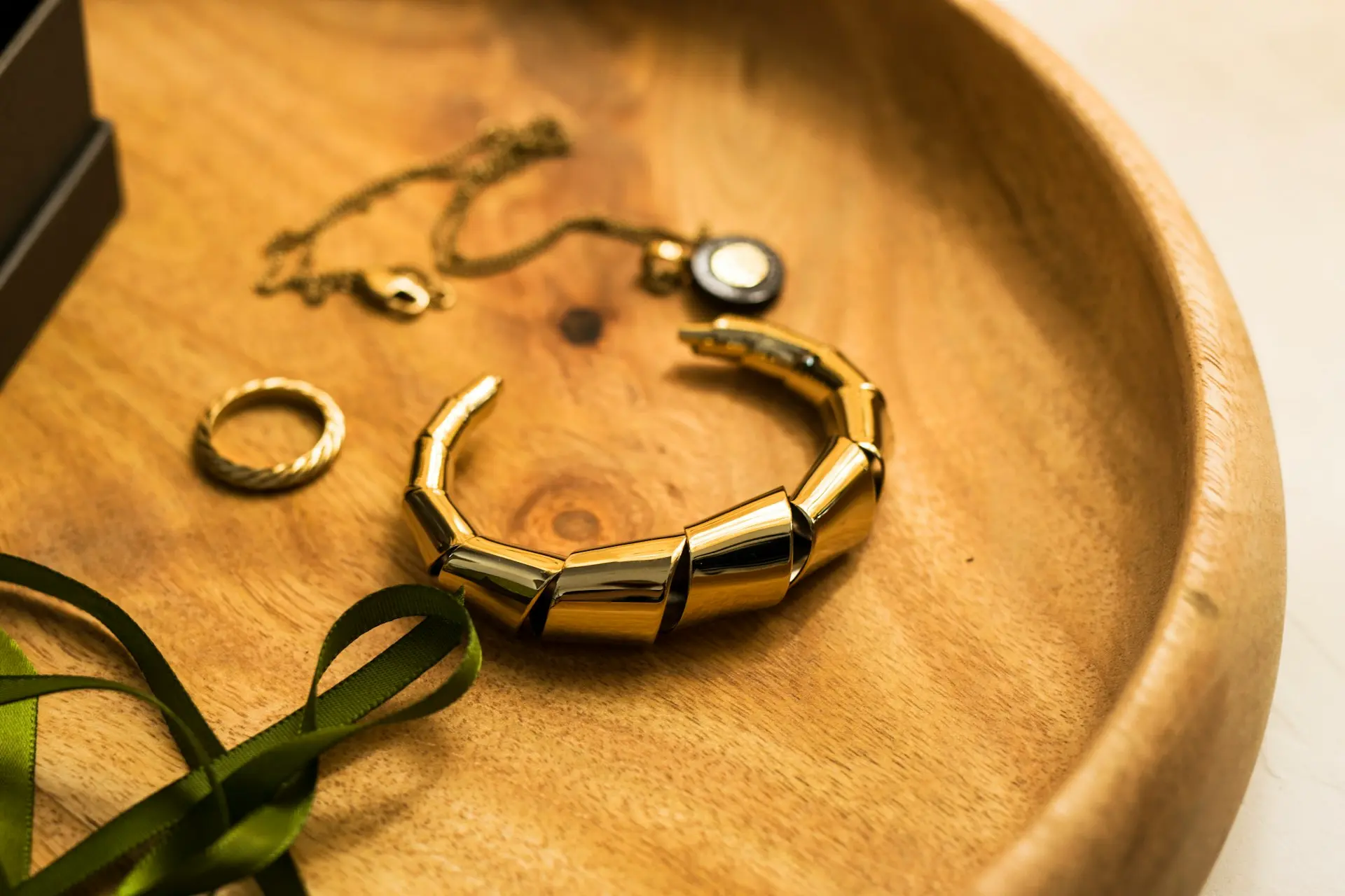 gold and green bracelet on brown textile